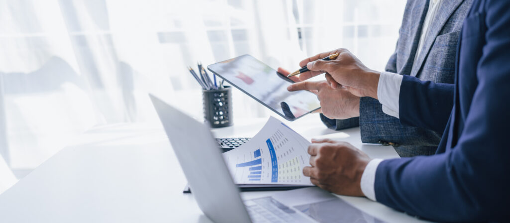 Two people look at graphs and statistics to make a decision.