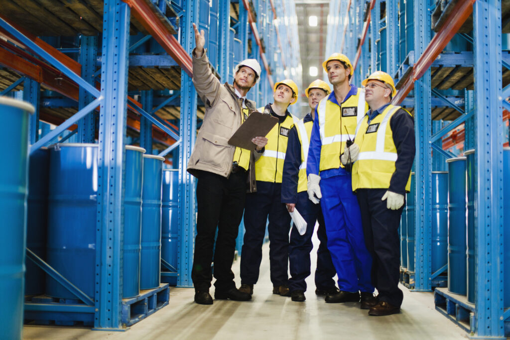 group of workers in a factory inspect shelving