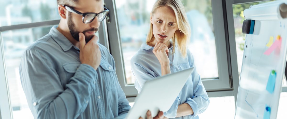 Man and woman thinking while looking at a lap top.